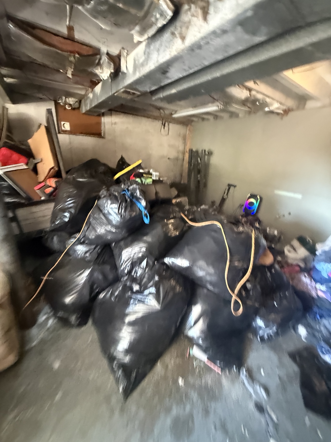 Bagged junk being removed from a garage